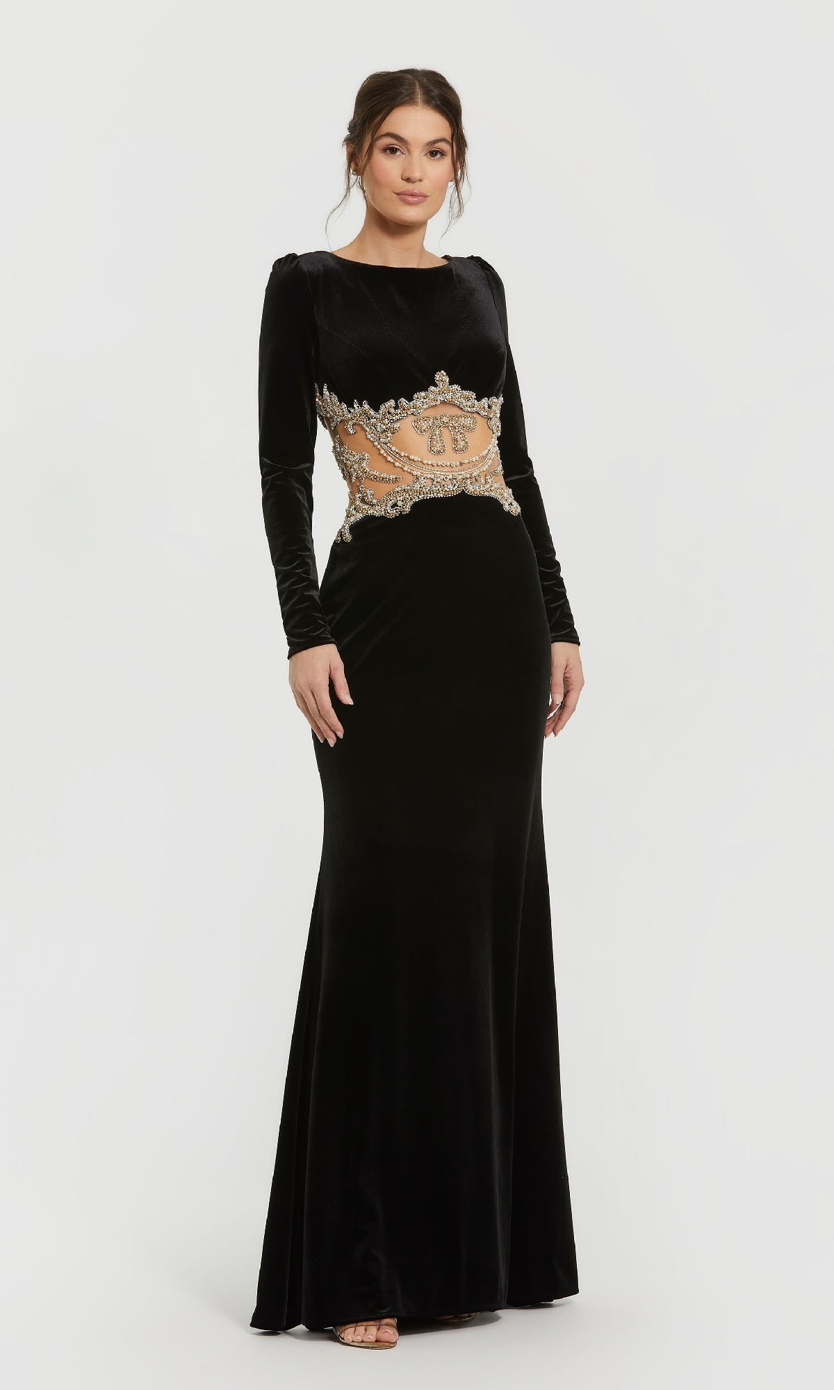 A woman in the Mac Duggal 79445 long formal dress, a black gown with long sleeves and gold-silver embellished waist detail, stands against a plain white background.